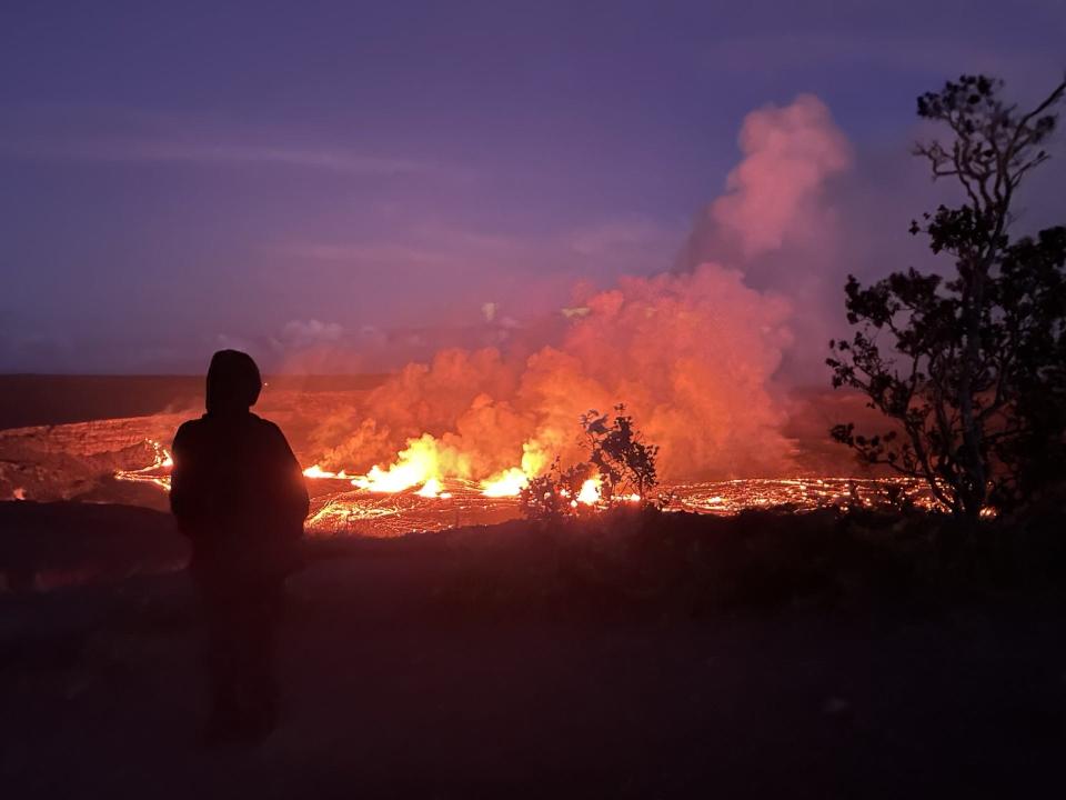 A visitor watches lava fountains within Halemaʻumaʻu Crater from Crater Rim Trail during Kīlauea's September 2023 eruption.