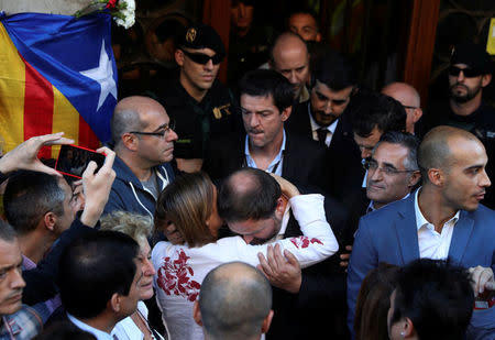 Catalan vice president Oriol Junqueras is embraced by president of Catalonian parliament Carme Forcadell outside the Catalan region's economy ministry building during a raid by Spanish police on government offices, in Barcelona, Spain, September 20, 2017. REUTERS/Susana Vera