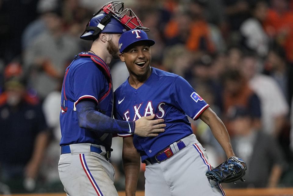 Texas Rangers' Jose Leclerc and Jonah Heim celebrate after Game 1 of the baseball AL Championship Series against the Houston Astros Sunday, Oct. 15, 2023, in Houston. The Rangers won 2-0 to take a 1-0 lead in the series. (AP Photo/David J. Phillip)