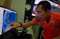 An official from Indonesia's national search and rescue agency in Medan points at his computer screen to the position where AirAsia flight QZ8501 went missing, December 28, 2014