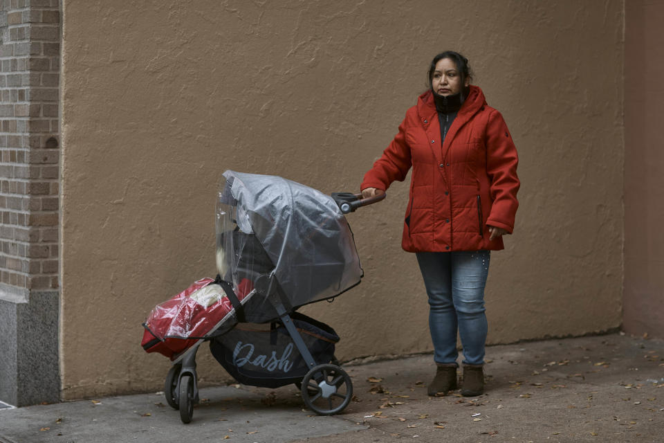 FILE _ Migrant Karina Obando, from Ecuador poses for a portrait in front of the Row Hotel that serves as migrant shelter together with her 3-year-old daughter Maily Caiza on Tuesday, Dec. 12, 2023, in New York. (AP Photo/Andres Kudacki, File)