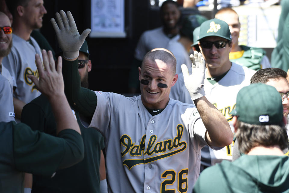 Oakland Athletics' Matt Chapman (26) is greeted in the dugout after hitting a home run against the Chicago White Sox during the first inning of a baseball game, Friday, Aug. 9, 2019, in Chicago. (AP Photo/David Banks)