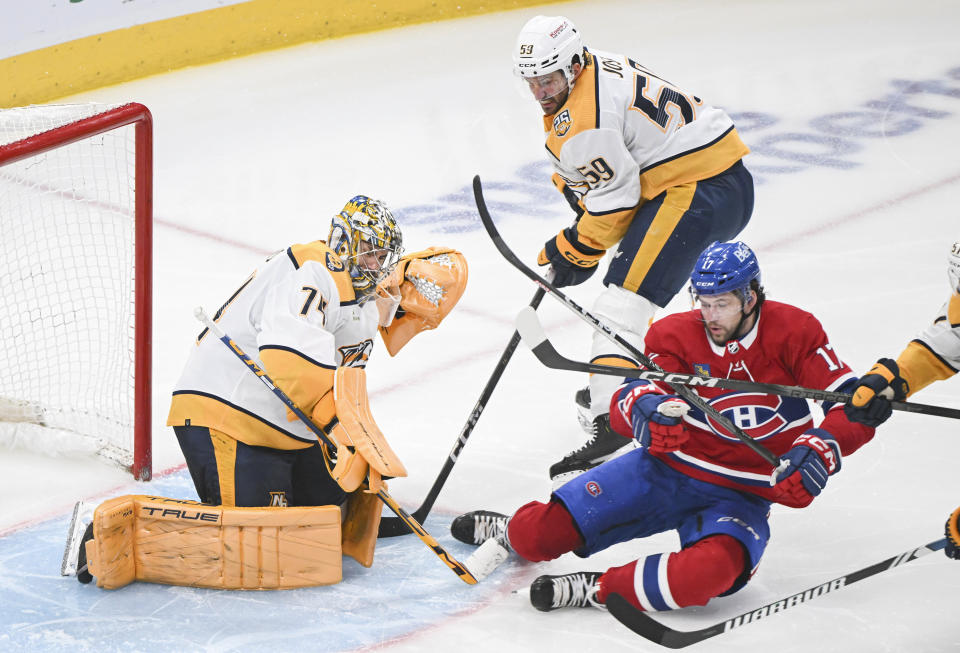 Montreal Canadiens' Josh Anderson (17) slides toward Nashville Predators goaltender Juuse Saros, left, as Predators' Roman Josi (59) defends during third-period NHL hockey game action in Montreal, Sunday, Dec. 10, 2023. (Graham Hughes/The Canadian Press via AP)