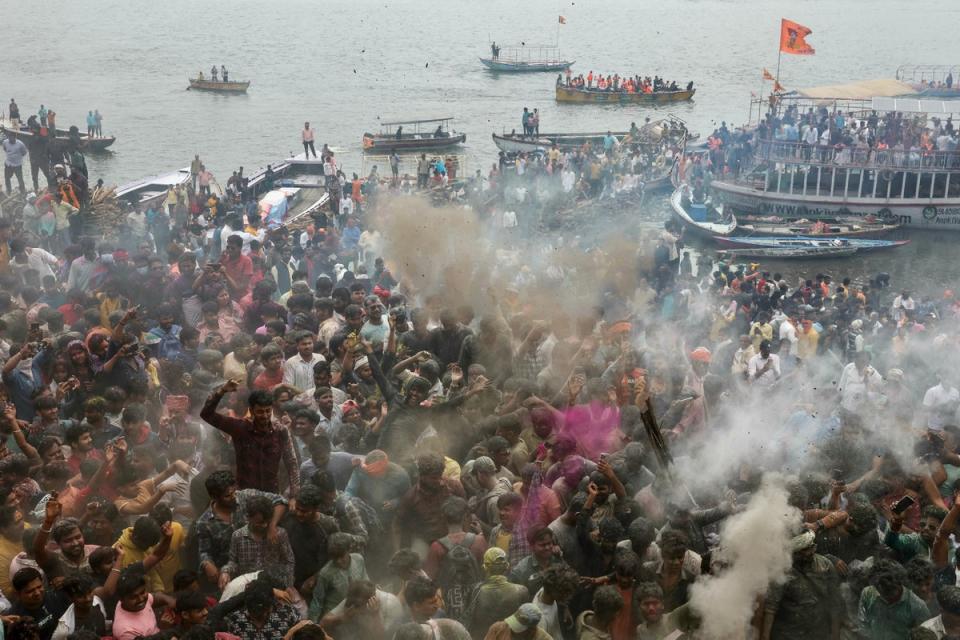 Hindu devotees gather at the Manikarnika Ghat as they take part in the 'Masaan or Bhasma' Holi, celebrated with ashes of funeral pyres, in Varanasi (AFP via Getty Images)