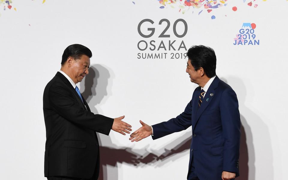 Chinese President Xi Jinping (L) is welcomed by Japanese Prime Minister Shinzo Abe (R) on the first day of the G20 summit last year. President Xi's state visit to Japan has now been cancelled because of the coronavirus - ANDY RAIN/EPA-EFE/REX