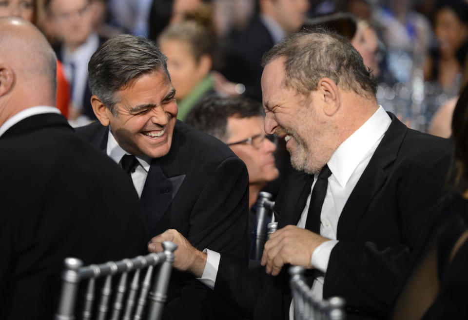 George Clooney and Harvey Weinstein share a laugh in 2013. Clooney called the accusations against Weinstein "disturbing" in part because many people may have covered them up. (Photo: Michael Kovac via Getty Images)