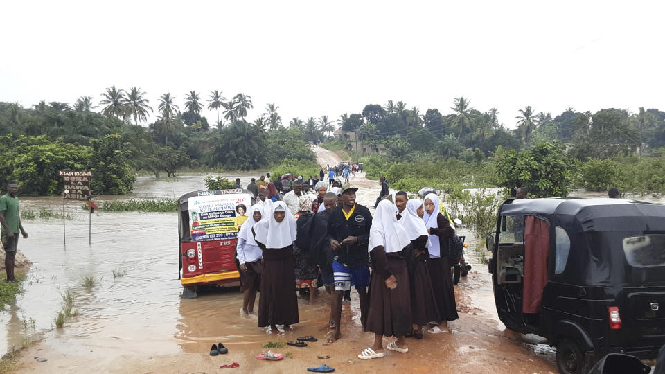 Schoolchildren stranded on a damaged River Zingiziwa bridge in Dar Esalaam, Tanzania Thursday, April 25, 2024. Flooding in Tanzania caused by weeks of heavy rain has killed 155 people and affected more than 200,000 others, the prime minister said Thursday. (AP Photo)