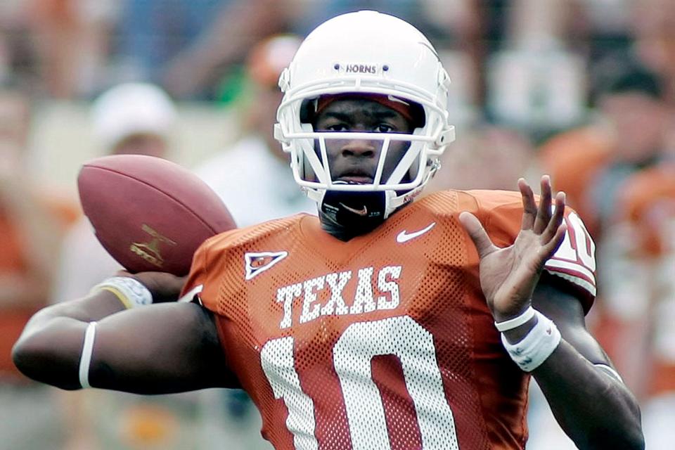 FILE - In this Nov. 12, 2005, file photo, Texas quarterback Vince Young looks to pass against Kansas during the second quarter of an NCAA college football game in Austin, Texas. Newly elected College Football Hall of Famers Darren McFadden, Vince Young and Lorenzo White never won the Heisman Trophy. Each was up for the award at a time when their credentials didn't quite fit the voting trends. (AP Photo/Eric Gay, File)