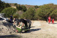 South Yorkshire police officers and members of the Greek rescue service (in red uniforms) investigate the ground while excavating a site during an investigation for Ben Needham, a 21-month-old British toddler who went missing in 1991, on the island of Kos, Greece, September 27, 2016. REUTERS/Vassilis Triandafyllou