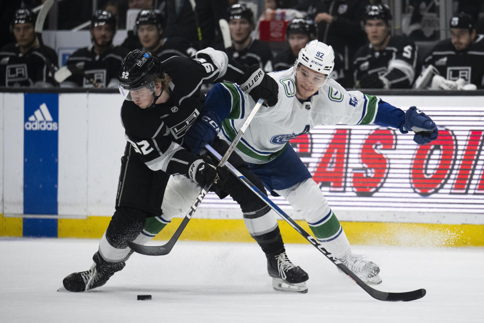 Los Angeles Kings defenseman Brandt Clarke (92) controls the puck away from Vancouver Canucks right wing Vasily Podkolzin (92) during the first period of an NHL hockey game, Tuesday, March 5, 2024, in Los Angeles. (AP Photo/Kyusung Gong)