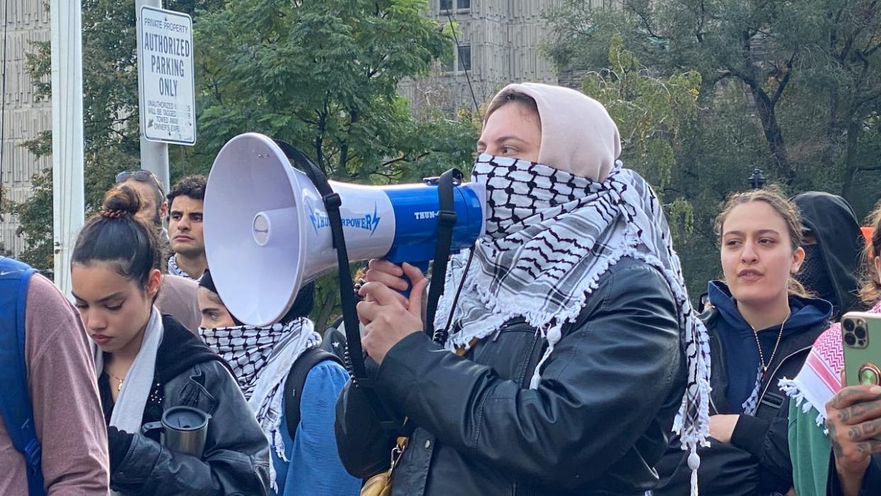 A pro-Palestinian demonstrator uses a megaphone to address a crowd in Toronto. There were four pro-Palestinian rallies in the city on Friday. (Prasanjeet Choudhury/CBC - image credit)