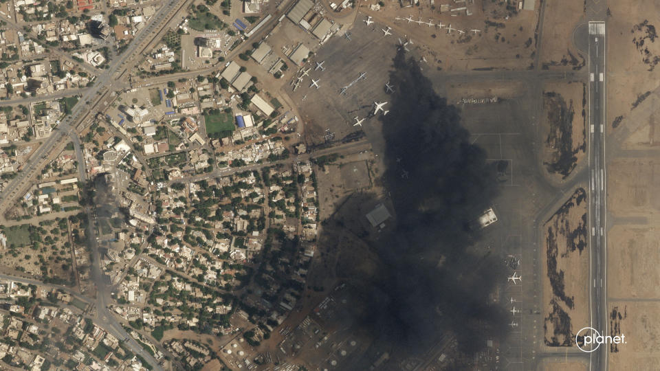 This satellite photo by Planet Labs PBC shows two burning planes at Khartoum International Airport, Sudan, Sunday April 16, 2023. The Sudanese military and a powerful paramilitary group are battling for control of the chaos-stricken nation for a second day. (Planet Labs PBC via AP)