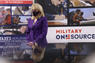 First lady Jill Biden points to a military service member pictured on a sign as she tours Military One Source, an active duty military resource hub/call center for service members, their family and survivors, in Arlington, Va, in Wednesday, April 7, 2021. In announcing the relaunch of Joining Forces, Biden said the initiative will focus on employment and entrepreneurship opportunities for military families, education for the more than 2 million children of enlisted parents and veterans, and the overall health and well-being of these families (Tom Brenner/Pool via AP)