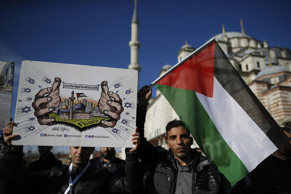 Protesters, one holding a Palestinian flag, participate in a rally against the proposed U.S. Mideast peace plan following Friday's Muslim prayers outside Fatih mosque in Istanbul, Friday, Jan. 31, 2020. U.S. President Donald Trump's Mideast plan would create a disjointed Palestinian state with a capital on the outskirts of east Jerusalem, beyond the separation barrier built by Israel. The rest of the Jerusalem, including the Old City, would remain Israel's capital. (AP Photo/Emrah Gurel)