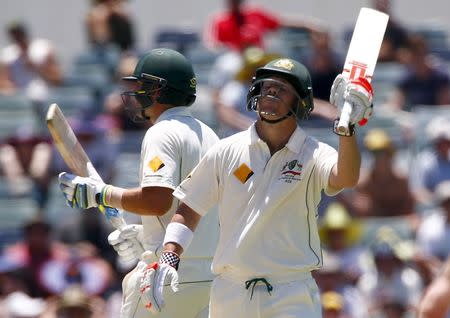 Australia's David Warner (R) reacts after being congratulated by team mate Joe Burns after reaching his fifty runs during the first day of the second cricket test match against New Zealand at the WACA ground in Perth, Western Australia, November 13, 2015. REUTERS/David Gray