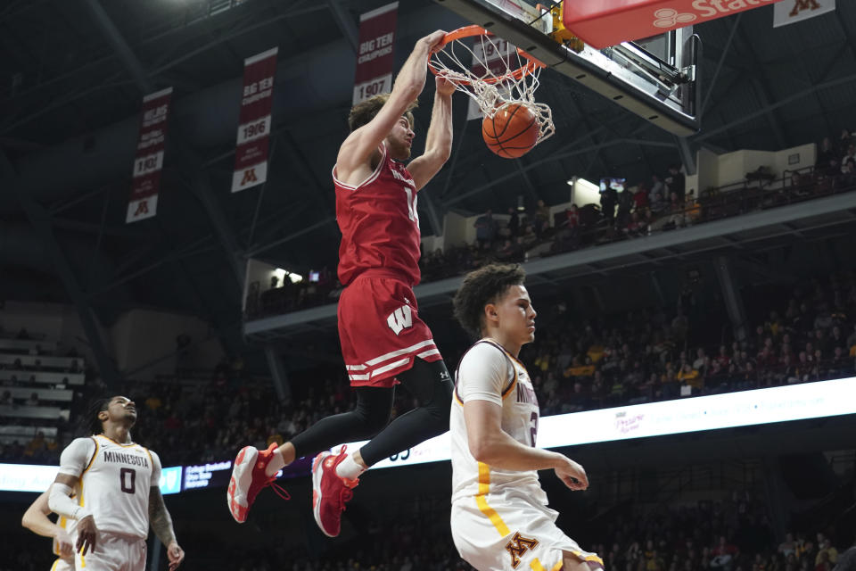 Wisconsin forward Carter Gilmore dunks over Minnesota guard Mike Mitchell Jr., as guard Elijah Hawkins (0) watches during the second half of an NCAA college basketball game Tuesday, Jan. 23, 2024, in Minneapolis. (AP Photo/Craig Lassig)