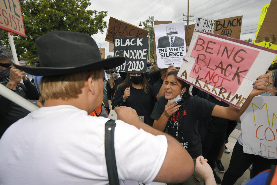 Demonstrators argue with Bruce Boyer, left, who was using a megaphone to ask protesters questions about why they were there during protest, Saturday, June 6, 2020, in Simi Valley, Calif. over the death of George Floyd. Protests continue throughout the country over the death of Floyd, a black man who died after being restrained by Minneapolis police officers on May 25. (AP Photo/Mark J. Terrill)