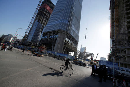 A man cycles past construction sites in Beijing's central business area, China, January 20, 2017. REUTERS/Jason Lee