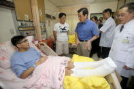 Taiwan President Ma Ying-jeou (C in blue) visits a man who sustained injuries in a fire at the Formosa Fun Coast water park at Taipei Veterans General Hospital in Taipei, Taiwan, June 28, 2015. REUTERS/Central News Agency/Pool