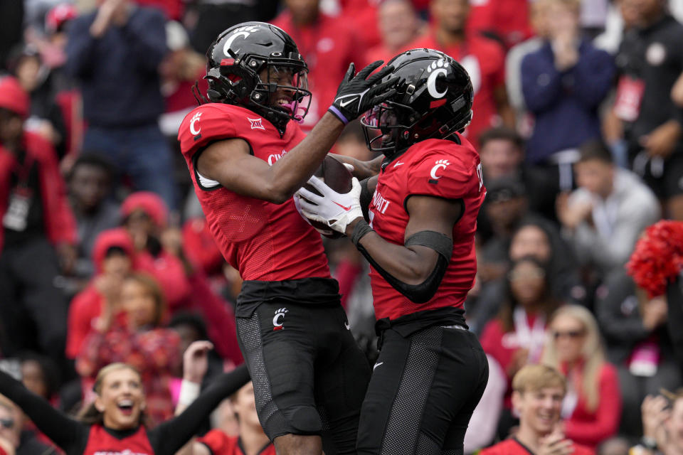 Cincinnati tight end Chamon Metayer, center right, celebrates with Xzavier Henderson after scoring a touchdown during the first half of an NCAA college football game against Iowa State, Saturday, Oct. 14, 2023, in Cincinnati. (AP Photo/Jeff Dean)