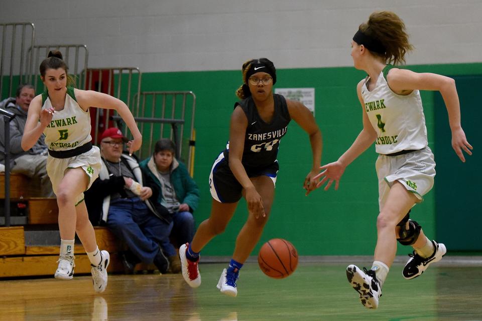 Newark Catholic's Maddie Kauble (left) and Kylie Gibson (right) try to chase down Zanesville sophomore Kandrea Sowers during their LCL crossover game Wednesday. The host Green Wave prevailed 40-36.