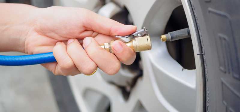 Hand adding air to a tire.