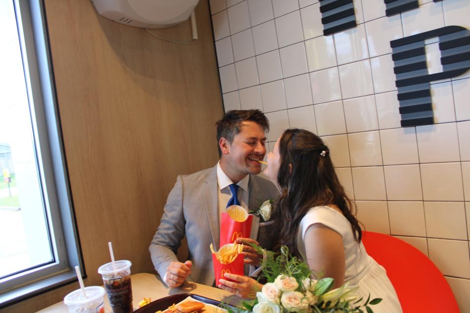 Mike and Kathi Haller, newlyweds from Munich, Germany, share fries at a local Michigan McDonald's following their wedding ceremony