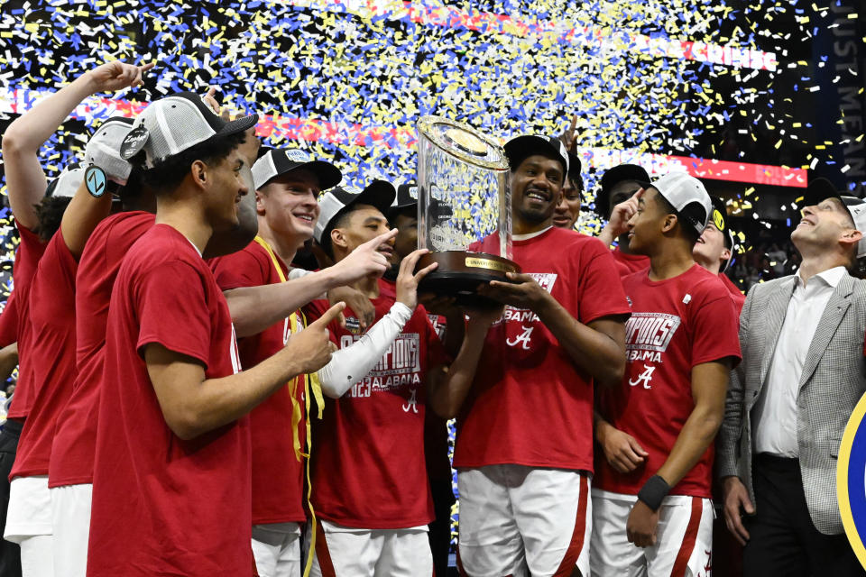 Alabama players pose with the trophy after an NCAA college basketball game against Texas A&M in the finals of the Southeastern Conference Tournament, Sunday, March 12, 2023, in Nashville, Tenn. Alabama won 82-63. (AP Photo/John Amis)