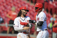 Cincinnati Reds' Nick Castellanos, right, celebrates hitting a three-run home run with Jonathan India during the sixth inning of a baseball game against the Pittsburgh Pirates in Cincinnati, Monday, Sept. 27, 2021. (AP Photo/Aaron Doster)