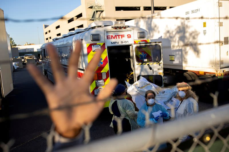 FILE PHOTO: An El Paso County Sheriff's Officer tries to block photographs from being taken as bodies are moved to refrigerated trailer