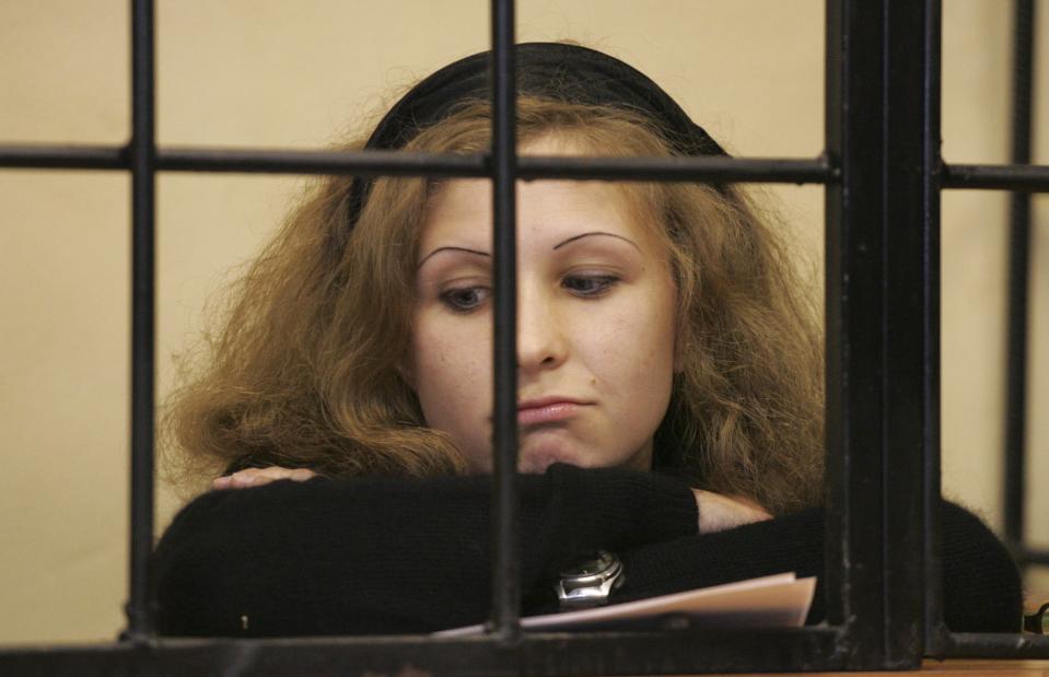 Maria Alyokhina, jailed member of Russian punk band Pussy Riot, looks out from a defendants' box as she attends a court hearing in Nizhny Novgorod