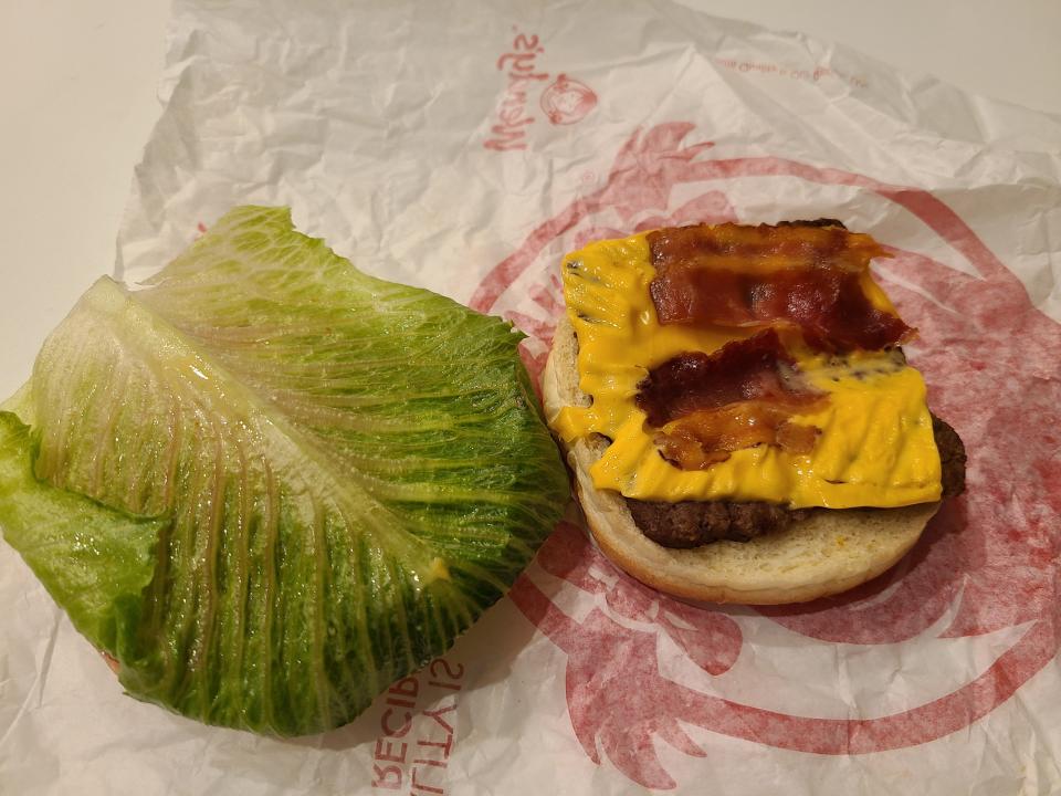 wendys jr bacon cheeseburger split open on white and red wrapper