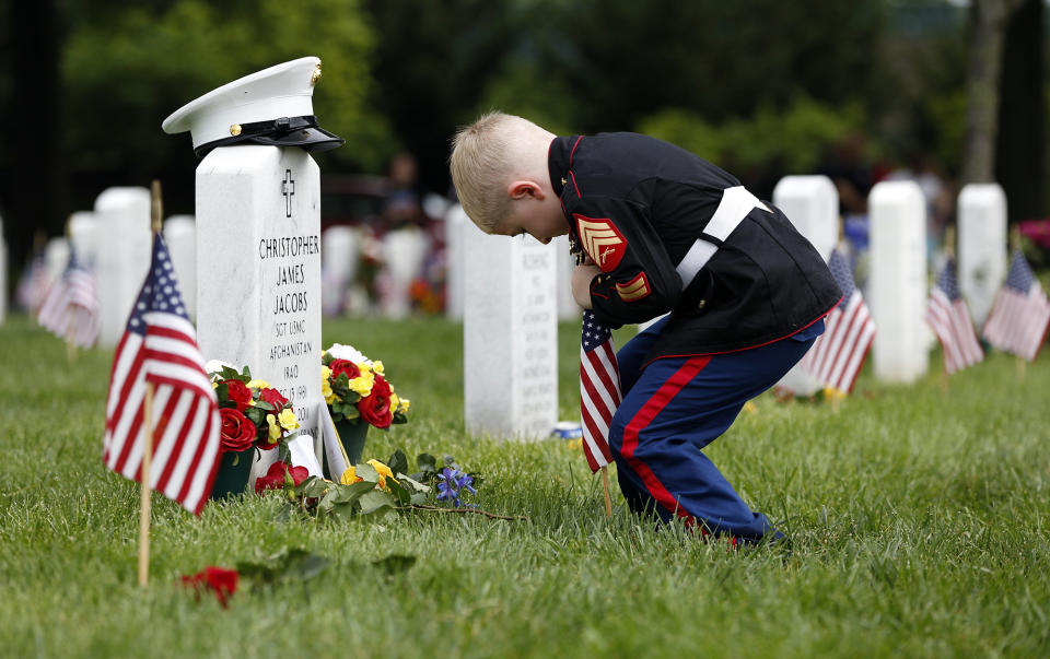 <p>Christian Jacobs, 5, of Hertford, N.C., dressed as a Marine, places a flag in front of his father’s gravestone on Memorial Day in Section 60 at Arlington National Cemetery on Monday, May 30, 2016. Christian’s father, Marine Sgt. Christopher James Jacobs, died in a training accident in 2011. (Photo: Carolyn Kaster/AP) </p>