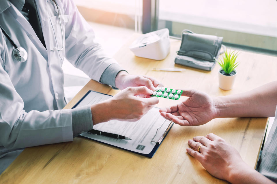 therapist consulting to patient male patient about pills writing his medical prescription drug in the office