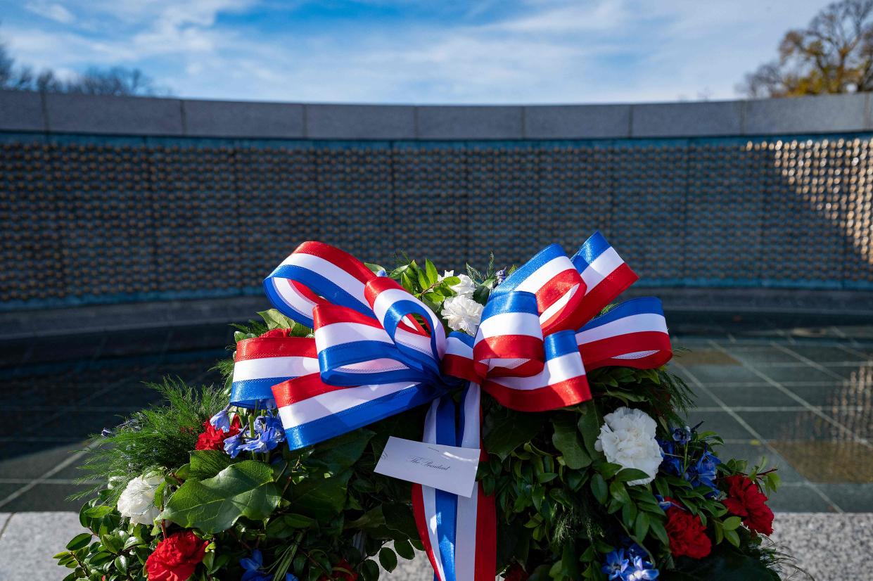 A wreath left by US President Joe Biden stands next to the Freedom Wall commemorating the 80th anniversary of the attack on Pearl Harbor at the National World War II Memorial in Washington, DC, on December 7, 2021.