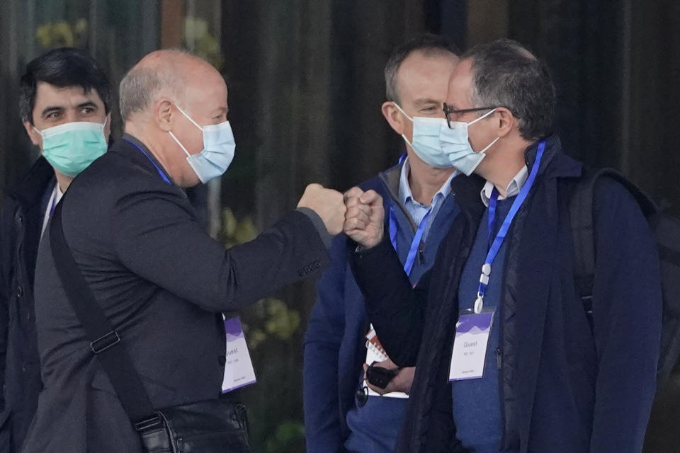 FILE - In this Feb. 2, 2021, file photo, Peter Daszak, left, bumps fists with Peter Ben Embarek before they leave the hotel with other members of a World Health Organization team for another day of field visit in Wuhan in central China's Hubei province. Daszak, part of the team investigating the origins of the coronavirus in Wuhan, says the Chinese side granted full access to all sites and personnel they requested to visit and meet with. (AP Photo/Ng Han Guan, File)