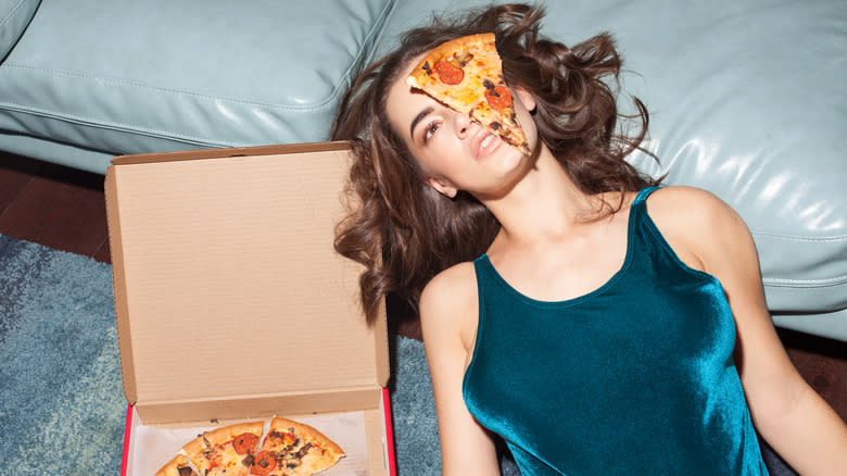pizza on woman's face