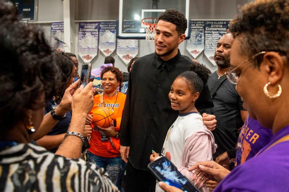 NBA star Devin Booker poses for a photo with fans after a ceremony for the retirement of Booker’s high school jersey at Moss Point High School in Moss Point on Saturday, Dec. 10, 2022.