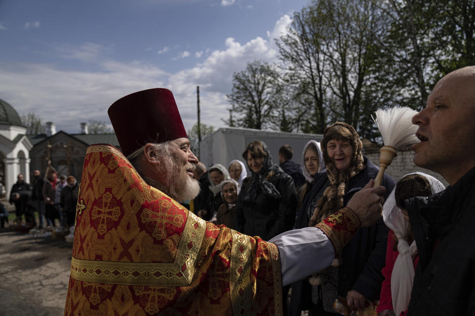 An Orthodox priest blesses believers during the Easter celebration at the All Saints church in Bahmut, eastern Ukraine, Sunday, April 24, 2022. (AP Photo/Evgeniy Maloletka)