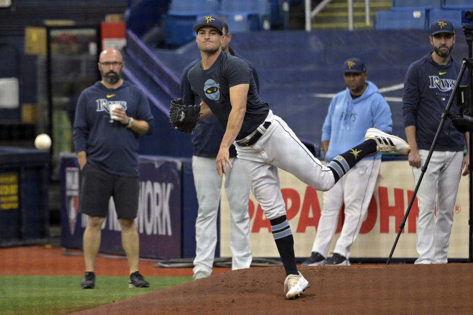 Tampa Bay Rays coaches and trainers look on as Shane McClanahan, center, throws a seven-pitch bullpen session before a baseball game against the Kansas City Royals Sunday, June 25, 2023, in St. Petersburg, Fla. McClanahan ended his previous game after four innings with back tightness. (AP Photo/Steve Nesius)