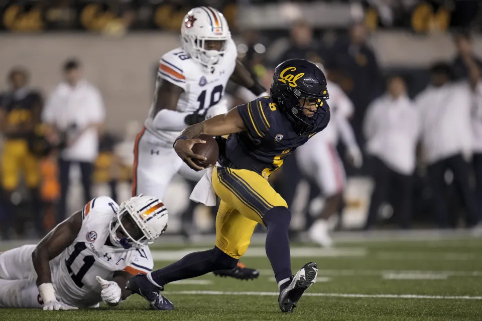 California quarterback Sam Jackson V (5) runs with the ball as Auburn's Elijah McAllister falls to the turf during the second half of an NCAA college football game Saturday, Sept. 9, 2023, in Berkeley, Calif. (AP Photo/Godofredo A. Vásquez)