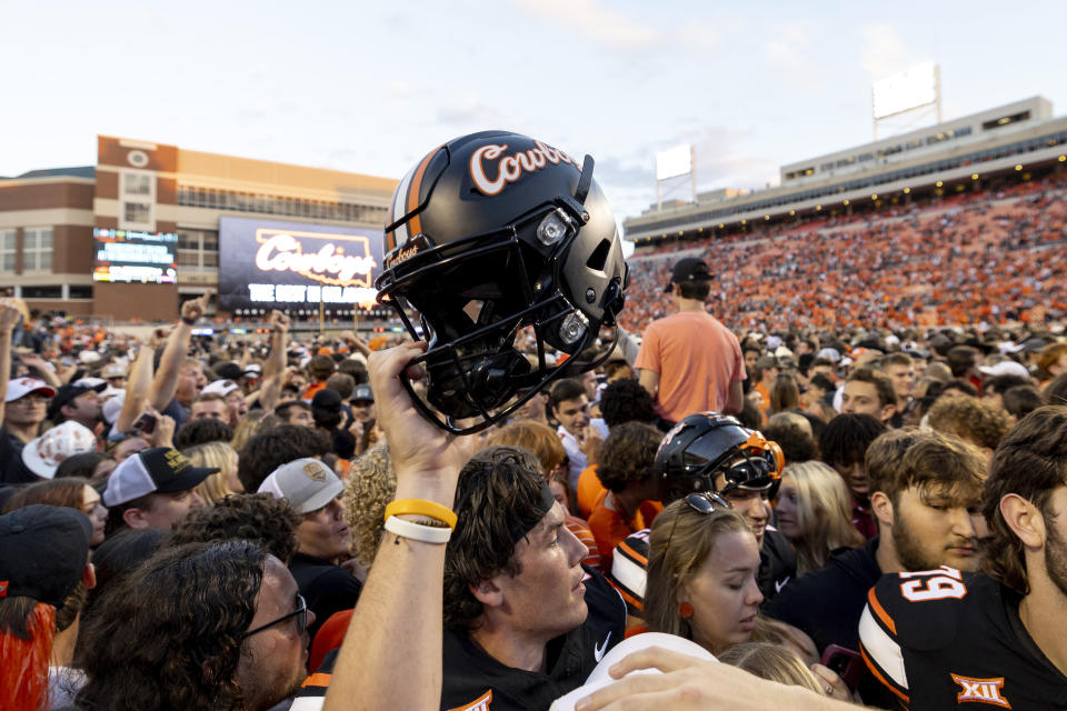 Fans rush the field after an Oklahoma State victory after an NCAA college football game against Oklahoma Saturday, Nov. 4, 2023, in Stillwater, Okla. (AP Photo/Mitch Alcala)