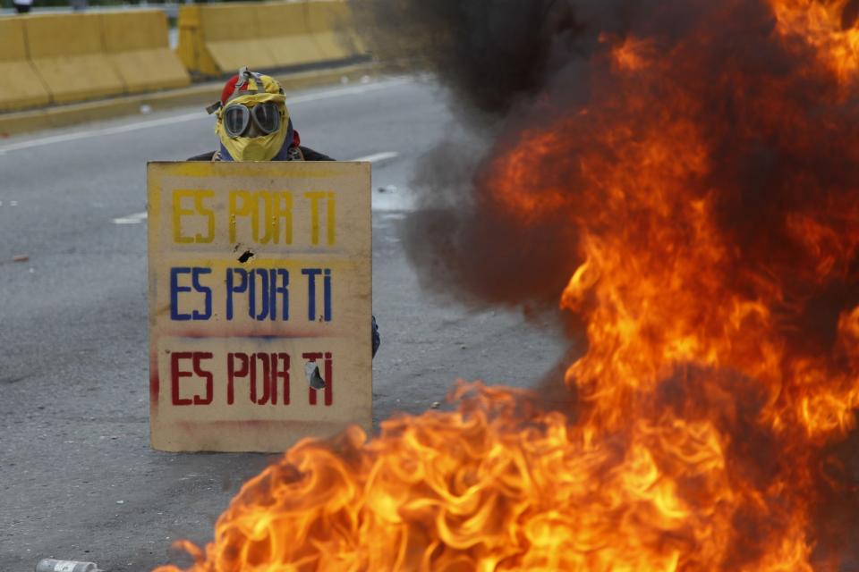 <p>A demonstrator holds a sign that doubles a shield that reads in Spanish “It’s for you,” during a national sit-in against President Nicolas Maduro, in Caracas, Venezuela, Monday, May 15, 2017. (AP Photo/Ariana Cubillos) </p>