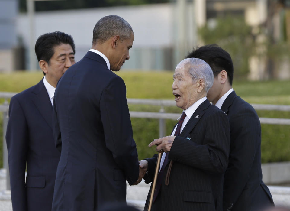 FILE - In this May 27, 2016, file photo, Sunao Tsuboi, right, a survivor of the 1945 Atomic Bombing and chairman of the Hiroshima Prefectural Confederation of A-bomb Sufferers Organization, talks with then U.S. President Barack Obama, center, accompanied by then Japanese Prime Minister Shinzo Abe, left, at Hiroshima Peace Memorial Park in Hiroshima, western Japan. Tsuboi, a survivor of the Hiroshima atomic bombing, who made opposing nuclear weapons the message of his life, including in a meeting with then President Obama in 2016, has died. He was 96.(AP Photo/Carolyn Kaster, File)