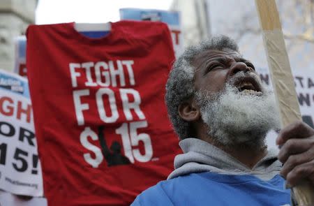 A demonstrator reacts as they gather on the sidewalk with placards during a protest for a $15-an-hour nationwide minimum wage in downtown Chicago, Illinois, April 14, 2016. REUTERS/Jim Young