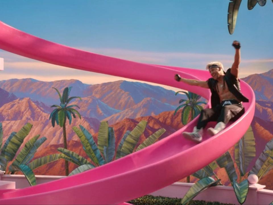 Barbie actors Ryan Gosling going down a slide