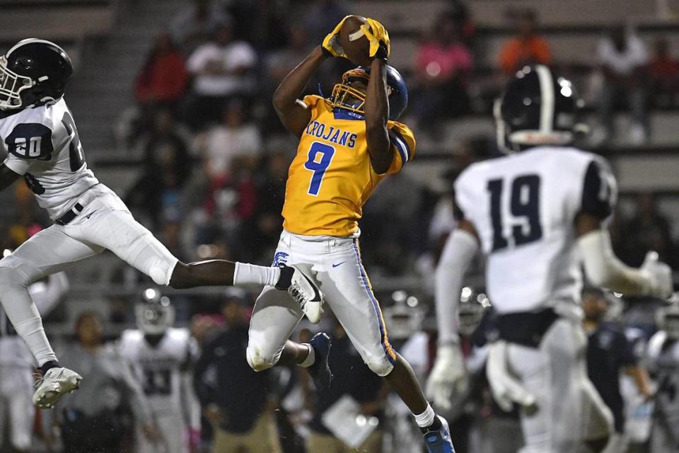 Garner’s Dwight Nesbitt (9) makes the pass reception against Southeast Raleigh’s Zykir Gbor (20) in the second half. The Garner Trojans and the Southeast Raleigh Bulldogs met in a conference football game in Garner, N.C, on October 6, 2023