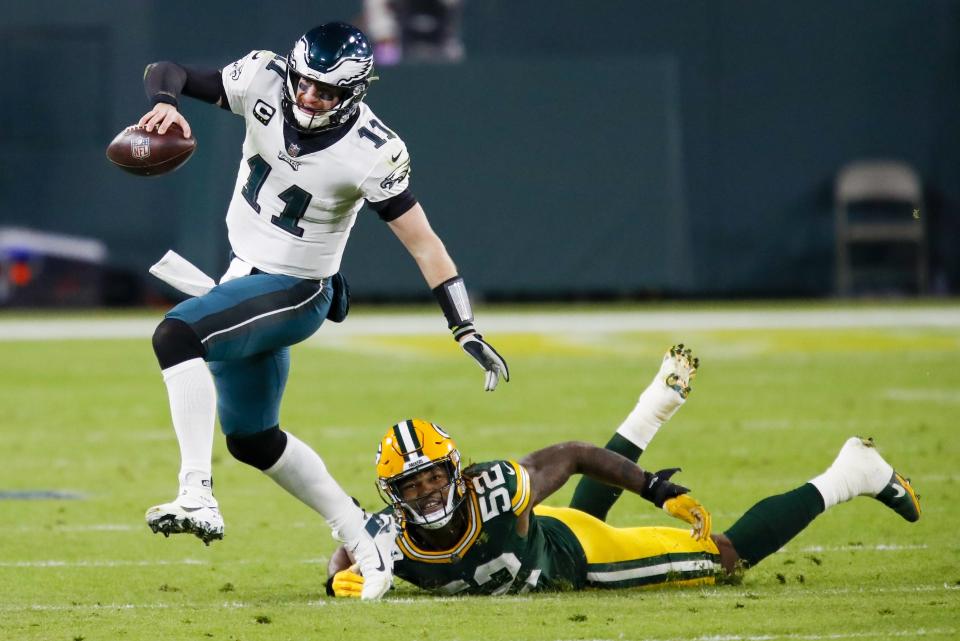 Green Bay Packers' Rashan Gary tries to stop Philadelphia Eagles' Carson Wentz during the first half of an NFL football game Sunday, Dec. 6, 2020, in Green Bay, Wis. (AP Photo/Matt Ludtke)