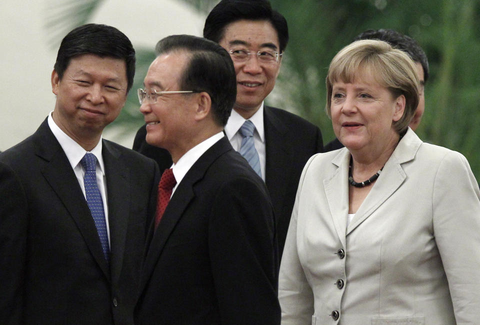German Chancellor Angela Merkel, right, and Chinese Premier Wen Jiabao, second from left, walk past Chinese officials during a welcome ceremony at the Great hall of the People in Beijing, Thursday, Aug. 30, 2012. (AP Photo/Ng Han Guan)