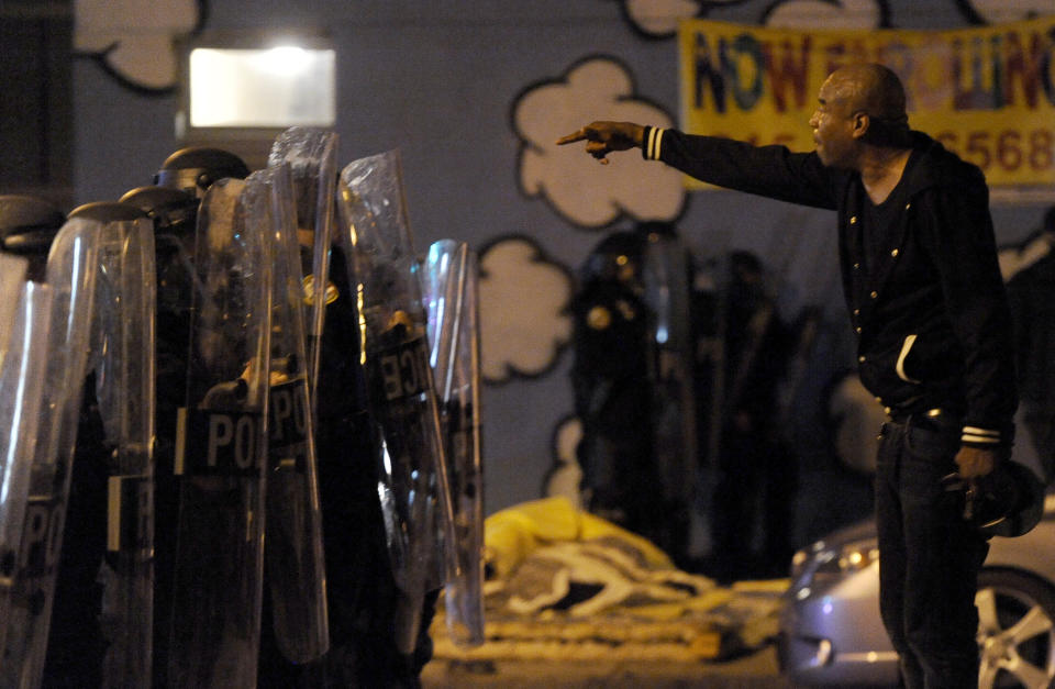 A protester points while facing police during a demonstration Tuesday night, Oct. 27, 2020, in Philadelphia. Hundreds of demonstrators marched in West Philadelphia over the death of Walter Wallace Jr., a Black man who was killed by police in Philadelphia on Monday. (AP Photo/Michael Perez)